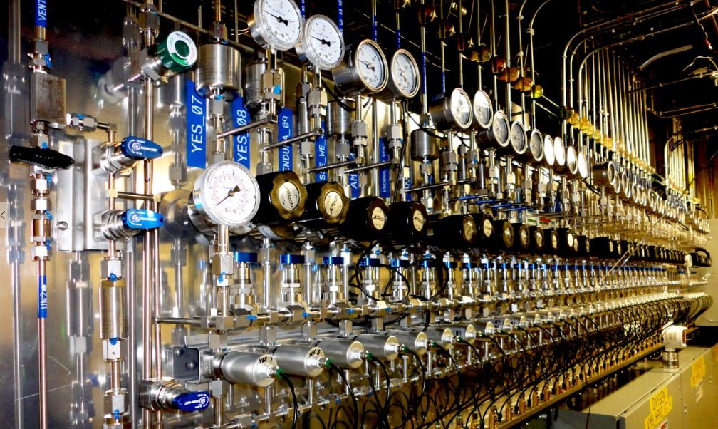 A complex panel with numerous pressure gauges, valves, pipes, and switches, all connected in an intricate system, likely used for monitoring and controlling industrial processes.